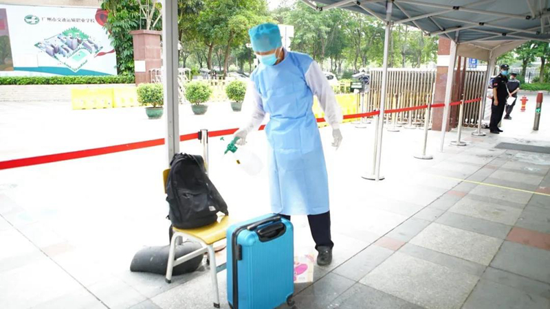 广州市交通运输职业学校医务人员帮学生消毒行李。.jpg