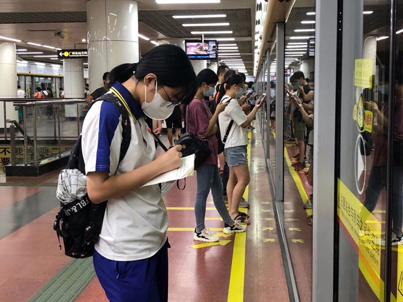 7点10分，地铁公园前站台，一名考生在等候地铁时抓紧时间复习。.jpg