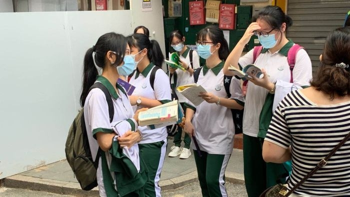 广州市第十七中学考点门口，考生抓紧时间看复习资料。.png