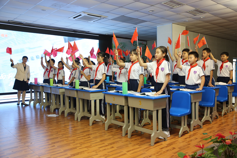 图5学生观看视频，并挥动手中的五星红旗，为祖国的繁荣昌盛喝彩.jpg